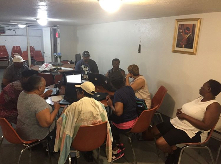 Adults seated in a community room during an eWasteGang information session.